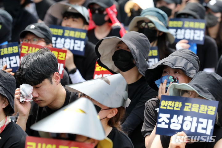 [서울=뉴시스] 조성우 기자 = 29일 오후 서울 종로구 정부서울청사 앞에서 열린 서이초 교사 추모 및 공교육 정상화 촉구 집회에서 한 참가자가 추모 영상을 보다 눈물을 흘리고 있다. 2023.07.29. xconfind@newsis.com