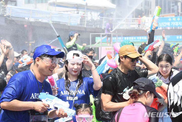 [장흥=뉴시스] 변재훈 기자 = 연일 찜통 더위가 이어지고 있는 30일 전남 장흥군 장흥읍 탐진강변 내 정남진 장흥 물 축제 주무대 주변 풀장에서 대규모 물총 싸움이 펼쳐지고 있다. 2023.07.30. wisdom21@newsis.com