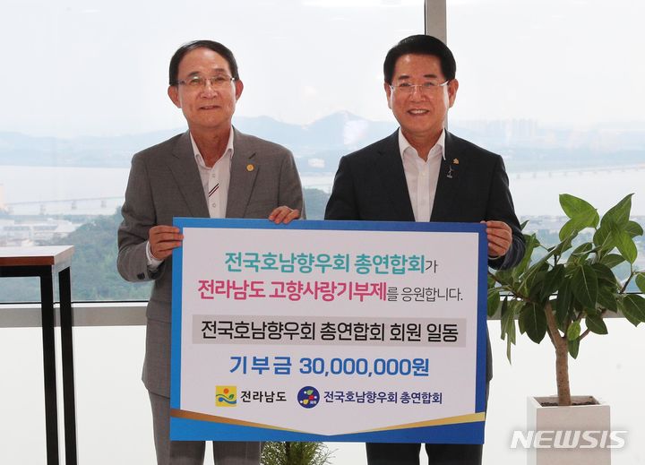 [무안=뉴시스] 이창우 기자=김영록 전남도지사(오른쪽)가 31일 오후 도청 장보고 전망대에서 전국호남향우회 총연합회 최순모 회장으로부터 고향사랑 기부금 3000만원을 기탁받고 있다. (사진=전남도 제공) 2023.07.31.photo@newsis.com *재판매 및 DB 금지