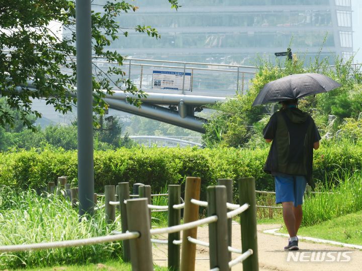 [인천=뉴시스] 김동영 기자 =  인천 연수구 송도 센트럴파크에서 시민이 양산으로 햇빛을 피하며 발걸음을 옮기고 있다. 사진과 기사는 관련 없음. 2023.8.1. dy0121@newsis.com