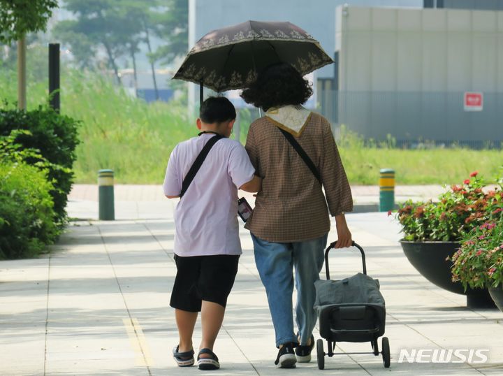 [인천=뉴시스] 김동영 기자 = 폭염경보가 발효 중인 1일 낮 인천 연수구 송도국제도시 한 인도에서 시민이 양산으로 햇빛을 피하며 발걸음을 옮기고 있다. 2023.8.1. dy0121@newsis.com 