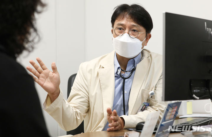 [서울=뉴시스] 최진석 기자 = 고윤호 가톨릭대학교 은평성모병원 종양내과 교수가 지난 1일 가톨릭대학교 은평성모병원 종양내과 외래진료실에서 최근 비소세포폐암이 재발한 환자 정선옥 씨를 진료하고 있다. 정 씨는 유한양행이 건강보험 적용 전까지 무상으로 제공하기로 한 폐암치료제 '렉라자' 동정적사용프로그램(EAP)의 3호 대상 환자로 등록됐다. 2023.08.02. myjs@newsis.com