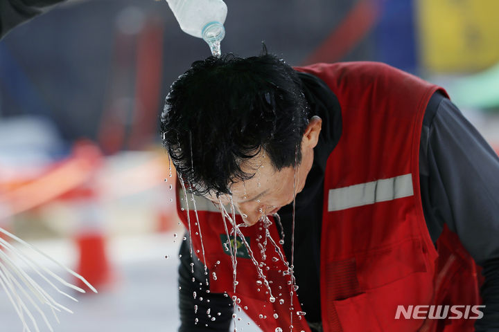 [인천공항=뉴시스] 최동준 기자 = 폭염이 이어지고 있는 지난해 8월2일 인천국제공항 제2합동청사 확장 등 8동 시설공사 근로자가 근로자 쉼터에서 물로 머리를 적시며 더위를 식히고 있다. 2023.08.02. photocdj@newsis.com