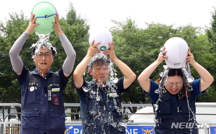 [서울=뉴시스] 최진석 기자 = 2일 서울 용산 대통령 집무실 앞에서 열린 민주노총 전국건설노조 폭염 대책 촉구 기자회견에서 건설노조 조합원들이 시원한 폭염법을 촉구하는 안전모 얼음물 붓기 퍼포먼스를 하고 있다. 2023.08.02. myjs@newsis.com