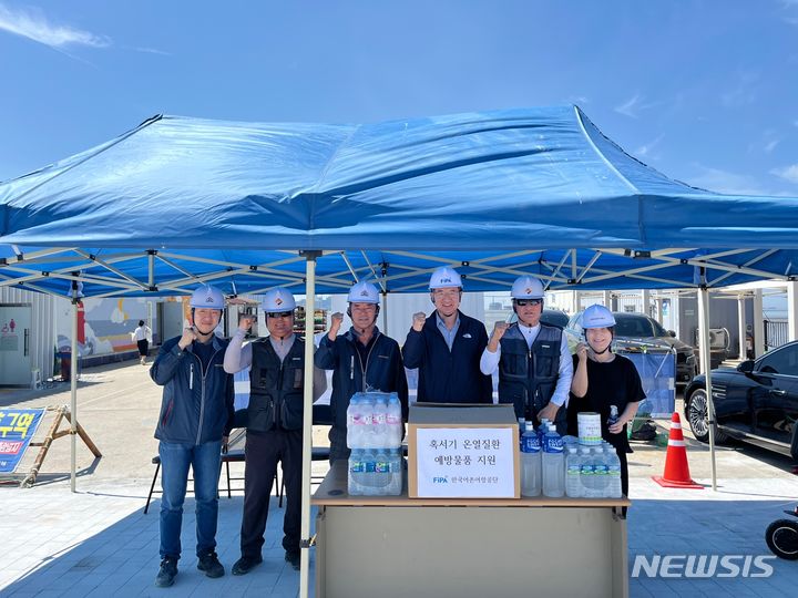 [서울=뉴시스] 박경철 한국어촌어항공단 이사장(오른쪽 세 번째)이 온열질환 예방 물품을 전달하는 모습. 