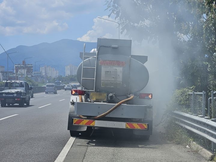 [창원=뉴시스] 강경국 기자 = 3일 낮 12시30분께 남해고속도로 1지선 함안방면 마산TG(톨게이트) 200m 지점 갓길에서 발연황산 24t을 적재한 탱크로리에서 적재물이 유출되고 있다. (사진=독자 제공). 2023.08.03. photo@newsis.com *재판매 및 DB 금지