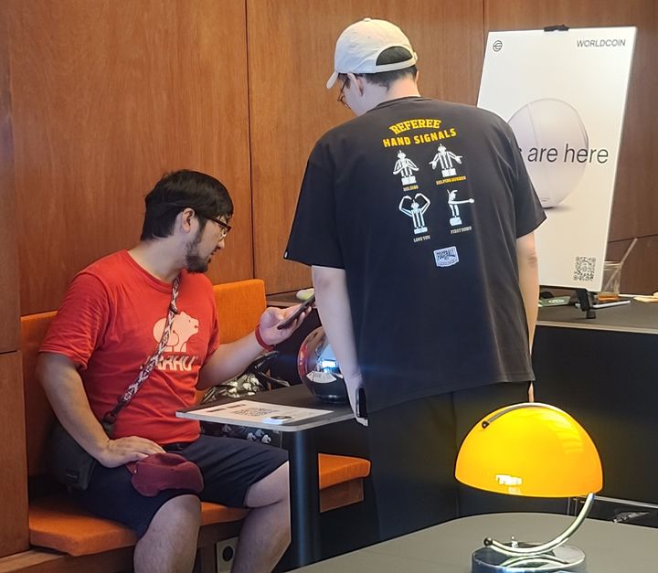 [서울=뉴시스] 3일 오후 오브가 설치된 을지로 카페에서 한 참여자가 운영자 안내에 따라 홍채를 등록하고 월드코인을 받고 있다. (사진=이지영 기자) 2023.08.03 *재판매 및 DB 금지