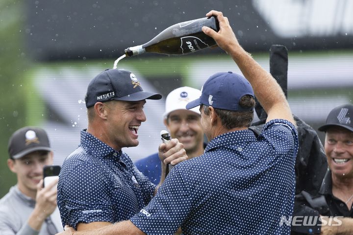 [화이트 설퍼 스프링스=AP/뉴시스] 브라이슨 디샘보(미국)가 6일(현지시각) 미 웨스트버지니아주 화이트 설퍼 스프링스의 올드 화이트 앳 그린브라이어에서 열린 리브(LIV) 골프 10차 대회 정상에 올라 축하 세례를 받고 있다. 디샘보는 최종 합계 23언더파 187타로 LIV 첫 정상에 올랐다. 2023.08.07.