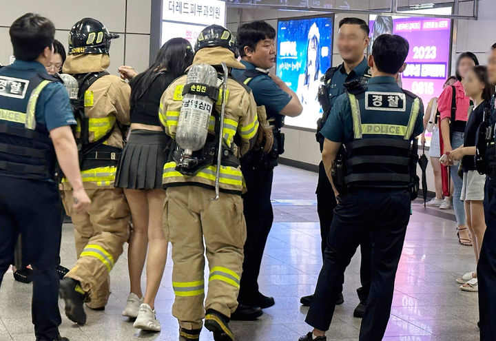 [서울=뉴시스] 조성봉 기자= 지난 6일 저녁 8시 38분께 서울 9호선 열차에서 흉기난동 및 생화학 테러 오인 신고가 연달아 접수돼 시민들이 신논현역에서 대피하는 소동이 빚어졌다. 사진은 6일 오인 신고로 신논현역에 출동한 경찰과 소방관들이 부상당한 시민을 부축하고 있다.(사진=독자제공) 2023.08.07. photo@newsis.com *재판매 및 DB 금지