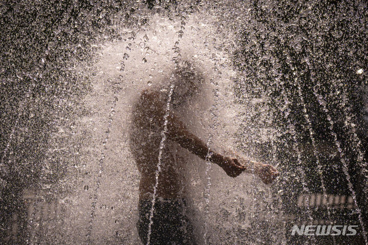 [부쿠레슈티(루마니아)=AP/뉴시스]루마니아 부쿠레슈티에서 지난 7월25일 폭염을 견디지 못한 한 남성이 분수대에 뛰어들어 물을 맞고 있다. 올해 7월은 지구상에서 가장 더운 달이었다고 '유럽연합(EU)의 코페르니쿠스 기후변화서비스'가 8일 공식 발표했다. 2023.08.08.