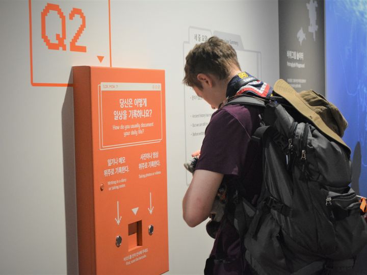 [서울=뉴시스]영국 스카우트 대원이 국립세계문자박물관 특별전 '긴 글 주의–문자의 미래는?'을 관람하며 설문에 참여하고 있다. (사진=국립세계문자박물관 제공) 2023.08.08. photo@newsis.com *재판매 및 DB 금지