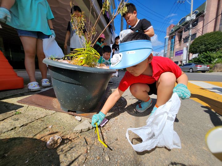 [고성(경남)=뉴시스] 신정철 기자= 경남 고성군 다함께돌봄센터 1호점(센터장 백정여)은 지난 8일 아동 15명과 저탄소 생활 실천 자원봉사 플로깅(쓰레기를 줍는 운동) 활동을 진행했다. 사진은 ‘오늘은 플로깅 데이’를 주제로 아이들은 고성군종합사회복지관 주변을 뛰어다니며 숨겨져 있는 쓰레기를 보물찾기 하듯이 줍고 있다.(사진=고성군 제공).2023.08.09. photo@newsis.com *재판매 및 DB 금지