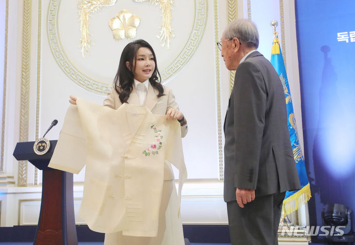 [서울=뉴시스] 홍효식 기자 = 윤석열 대통령 부인 김건희 여사가 9일 청와대 영빈관에서 열린 독립유공자 및 유족 초청 오찬에서 김영관 애국지사에게 무궁화 자수 한산모시 적삼을 선물하고 있다. 2023.08.09. yesphoto@newsis.com