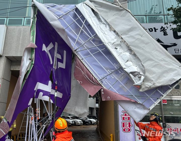 [화순=뉴시스] 김혜인 기자 = 10일 오전 전남 화순군 화순읍 한 건물 간판이 강풍에 떨어져 소방 당국이 전선에 걸린 간판을 제거하고 있다. 2023.08.10. (사진=전남도소방본부 제공) photo@newsis.com *재판매 및 DB 금지