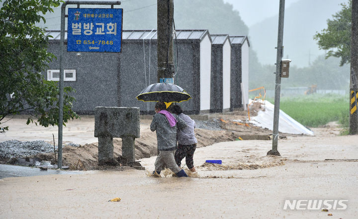 [예천=뉴시스] 이무열 기자 = 태풍 '카눈'이 북상한 10일 오후 경북 예천군 감천면 벌방리 주민들이 집으로 가기 위해 침수된 도로를 건너고 있다. 2023.08.10. lmy@newsis.com