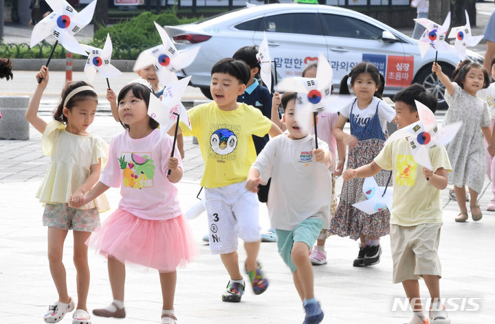 [광주=뉴시스] 광주 북구청 앞 광장에서 북구청 직장어린이집 원아들이 태극기 문양 바람개비를 든 채 뛰놀고 있다. (사진=뉴시스 DB). photo@newsis.com