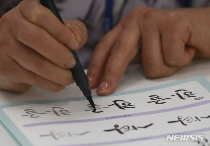 [서울=뉴시스] 김근수 기자 = 국외거주 독립유공자 한 후손이 14일 오전 서울 용산구 한글박물관에서 붓글씨 캘리그래피 체험을 하고 있다. 2023.08.14. ks@newsis.com