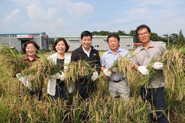 [고성(경남)=뉴시스] 신정철 기자= 경남 고성군은 지난 14일 고성읍 우산리 김형성 농가에서 올해 첫 벼 수확을 했다. 이날 풍년을 기원하는 첫 벼 수확 현장에는 이상근 고성군수(가운데), 최을석 고성군의회 의장, 허동원 도의원, 김향숙 고성군의회 부의장, 허옥희 군의원과 김진규 고성군 쌀전업농연합회장(오른쪽) 및 회원  30여 명이 참석해 첫 수확을 축하했다.(사진=고성군 제공).2023.08.15. photo@newsis.com *재판매 및 DB 금지