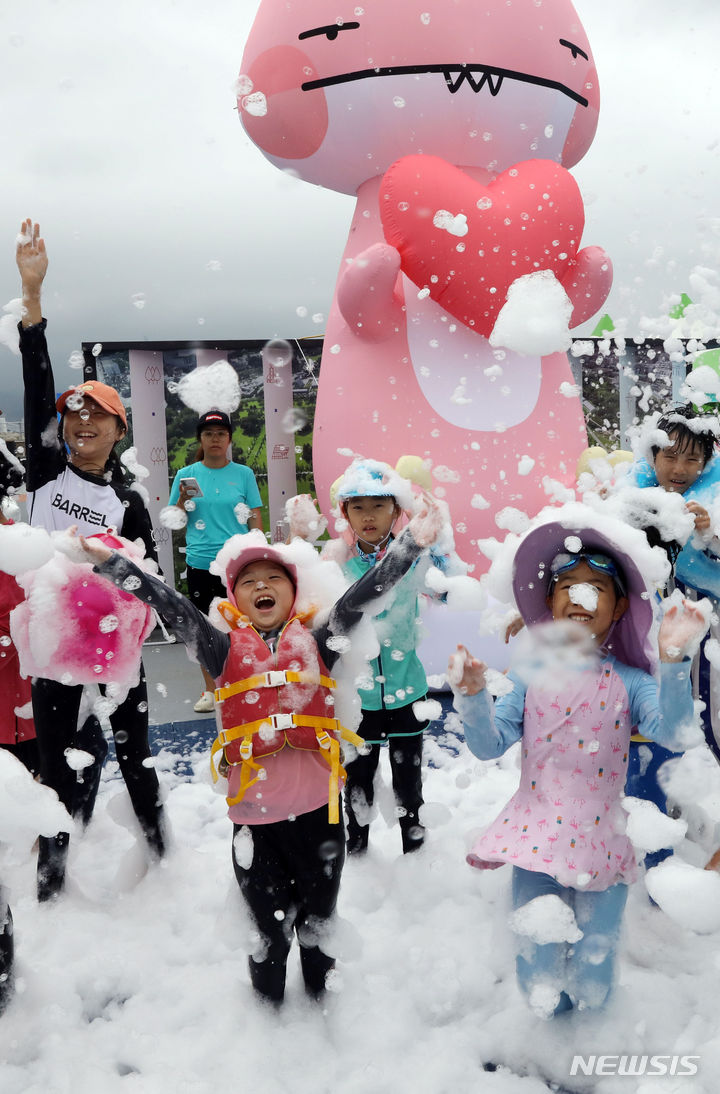 [부산=뉴시스] 하경민 기자 = 부산지역에 엿새째 폭염주의보 발효 중인 16일 남구 용호별빛공원에서 열린 '2023년 남구 물놀이 축제'를 찾은 어린이들이 인체에 무해한 거품 눈을 맞고 있다. 오는 20일까지 운영되는 물놀이축제에는 수영장 4개와 워터슬라이드, 페달보트, 챌린저바운스 등 물놀이 시설을 비롯해 물총싸움과 마술공연, 댄스공연 등 부대행사도 마련된다. 2023.08.16. yulnetphoto@newsis.com