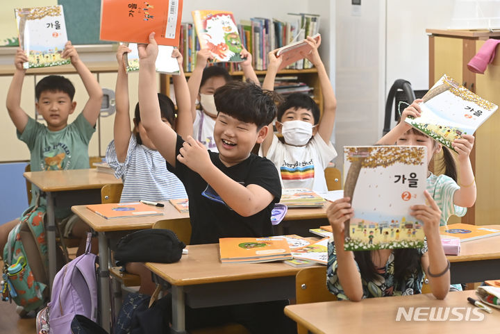 [수원=뉴시스] 김종택 기자 = 초등학교 개학이 시작된 16일 오전 경기도 수원시 영화초등학교 2학년1반 학생들이 새학기 교과서를 들어보이며 즐거워하고 있다. 2023.08.16. jtk@newsis.com