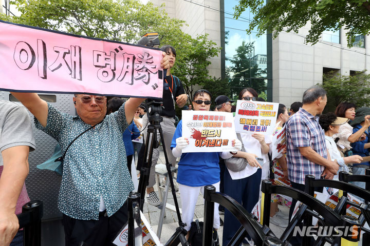 [서울=뉴시스] 조성봉 기자= 17일 오전 서울 서초구 서울중앙지검 인근에서 이재명 더불어민주당 대표 지지자들이 검찰을 규탄하는 손피켓을 들고 있다. 이날 이 대표는  '백현동 특혜 의혹'과 관련해 특경법상 배임 혐의로 서울중앙지검에 출석할 예정이다. 2023.08.17. suncho21@newsis.com