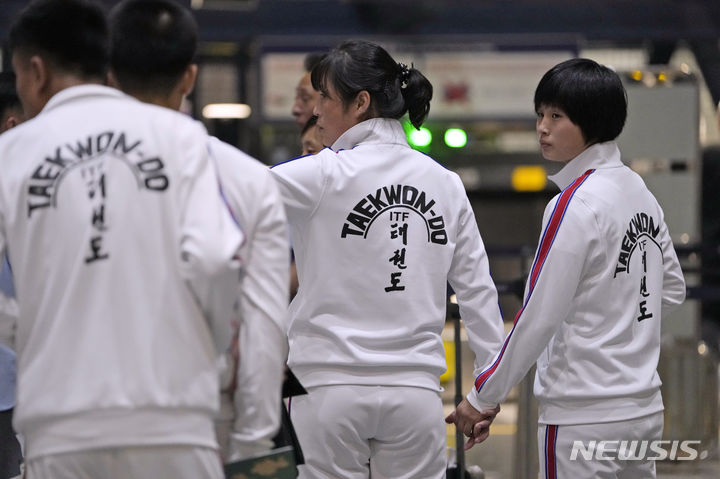 [베이징=AP/뉴시스] 18일 중국 베이징 공항에서 북한 국기가 찍힌 운동복을 입은 북한 여자 태권도 선수단이 카자흐스탄 아스타나행 항공기 탑승 수속을 하고 있다. 북한 태권도 선수단은 국제 태권도 대회 출전을 위해 중국을 거쳐 카자흐스탄 수도 아스타나로 이동 중인 것으로 알려졌다. 2023.08.18.