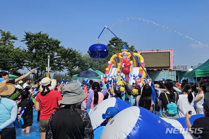 [인천=뉴시스] 이루비 기자 = 19일 인천 계양구 장기동 황어광장 일원에서 열린 '제1회 계양 아라뱃길 워터축제'를 찾은 시민들이 물총으로 박 터뜨리기 놀이를 즐기고 있다. 20일까지 진행되는 이번 행사는 수상레저 체험을 비롯해 물놀이존, 물총놀이 이벤트, 버스킹 공연 등 다양한 프로그램으로 구성됐다. 2023.08.19. ruby@newsis.com