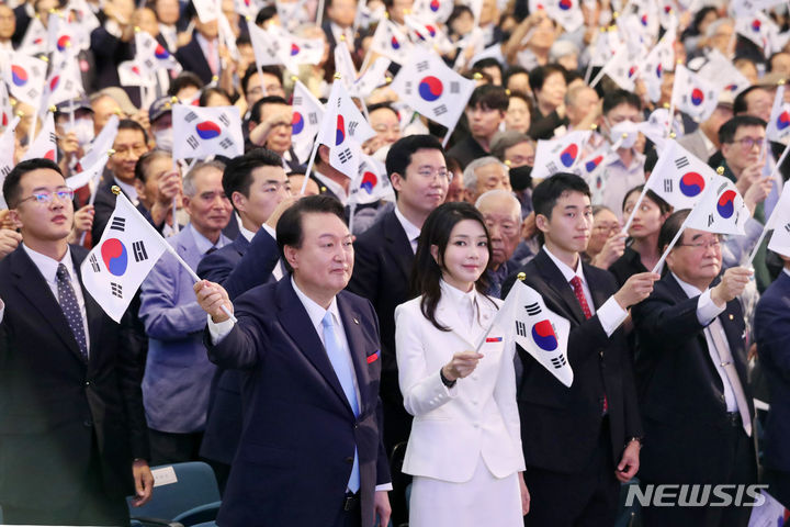 [서울=뉴시스] 홍효식 기자 = 윤석열 대통령과 부인 김건희 여사가 15일 오전 서울 서대문구 이화여대 대강당에서 열린 제78주년 광복절 경축식에서 만세삼창을 한 뒤 태극기를 흔들고 있다. 2023.08.15. yesphoto@newsis.com