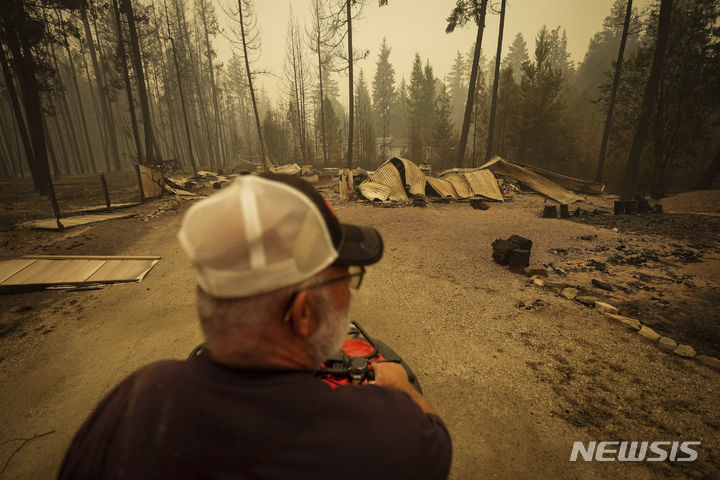 [스코치 크리크=AP/뉴시스] 20일(현지시각) 캐나다 브리티시컬럼비아주 스코치 크리크에서 한 주민이 산불로 파괴된 주택 잔해를 바라보고 있다. 쥐스탱 트뤼도 총리는 브리티시컬럼비아주의 산불 진화를 위해 군대를 파견한다고 밝혔다. 2023.08.28.