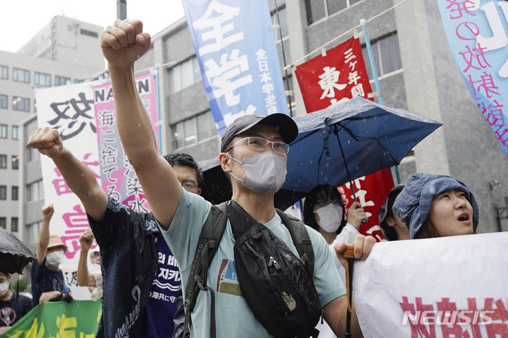[도쿄=AP/뉴시스] 22일 비 내리는 일본 도쿄의 총리관저 앞에서 시위대가 후쿠시마 원자력 발전소 방사능 오염수 방류에 반대하는 구호를 외치고 있다. 일본 정부는 후쿠시마 제1 원전 오염수를 이르면 24일부터 바다에 방류하기로 했다. 2023.08.22.