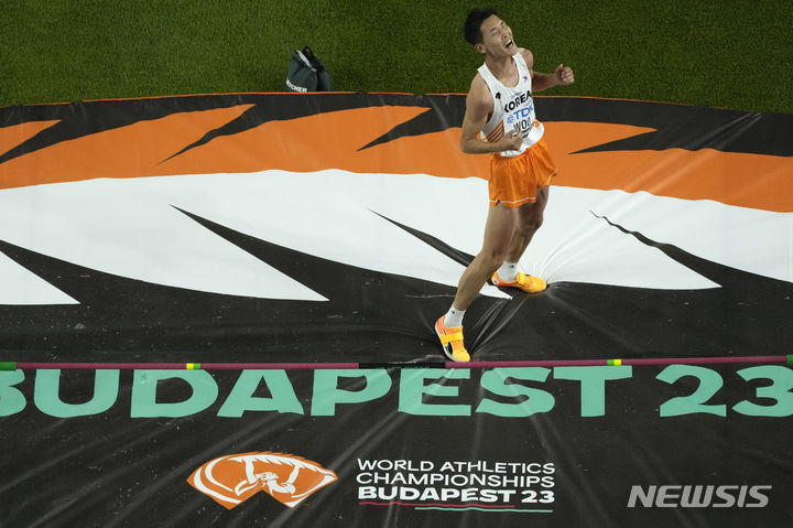 [부다페스트=AP/뉴시스] 우상혁이 22일(현지시각) 헝가리 부다페스트 국립육상경기장에서 열린 2023 세계육상선수권대회 남자 높이뛰기 결선에서 바를 넘은 후 환호하고 있다. 우상혁은 최종 2m29를 넘어 6위를 기록했다. 2023.08.23. 