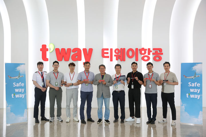서울 강서구 티웨이항공 훈련센터에서 정홍근 티웨이항공 대표(가운데)와 운항본부 임직원들이 슬로건이 새겨진 키링을 들고 기념촬영을 하고 있다. *재판매 및 DB 금지