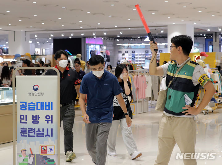 [서울=뉴시스] 김금보 기자 = 공습대비 민방위훈련이 실시된 23일 오후 서울 중구 롯데아울렛 서울역점에서 시민들이 민방위대원의 통제에 따라 대피하고 있다. 2023.08.23. kgb@newsis.com