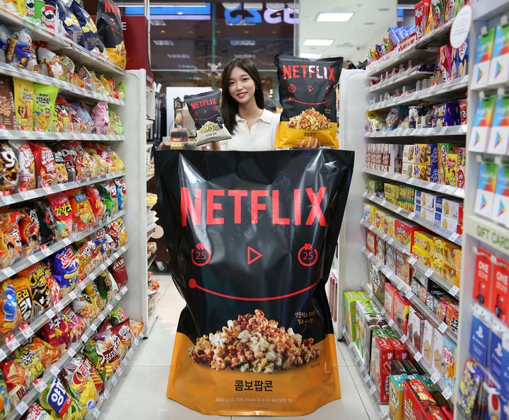 모델이 넷플릭스인간팝콘 뒤에서 넷플릭스트러플팝콘과 넷플릭스점보팝콘을 들고 있다.(사진=GS25 제공) *재판매 및 DB 금지