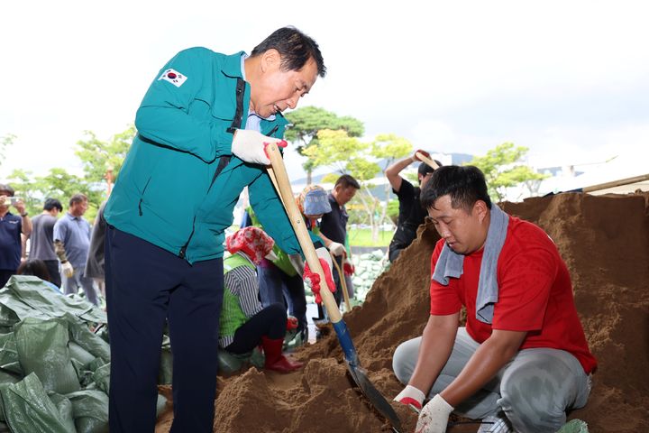 [양산=뉴시스] 안지율 기자 = 나동연 경남 양산시장이 24일 양산종합운동장에서 마련된 겨울철 폭설 등 재난 대비를 위해 모래주머니 만들기 행사장을 방문해 모래주머니를 만들고 있다. (사진=양산시 제공) 2023.08.25. photo@newsis.com *재판매 및 DB 금지