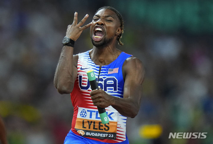[부다페스트=AP/뉴시스] 노아 라일스(미국)가 27일(한국시간) 헝가리 부다페스트 국립경기장에서 열린 2023 세계육상선수권대회 남자 400m 계주 결선에서 결승선을 통과하며 손가락 세 개를 펴보이고 있다. 2023.08.27