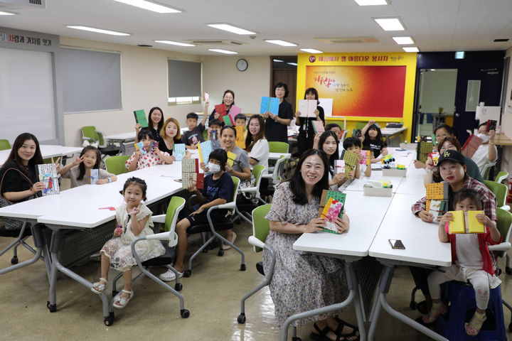 [수원=뉴시스] 다문화 가족들이 26일 수원시자원봉사센터 4층 대강당에서 직접 만든 ‘한지 북아트’를 들고 기념 촬영을 하고 있다. (사진=수원시자원봉사센터 제공) 2023.08.27. photo@newsis.com *재판매 및 DB 금지