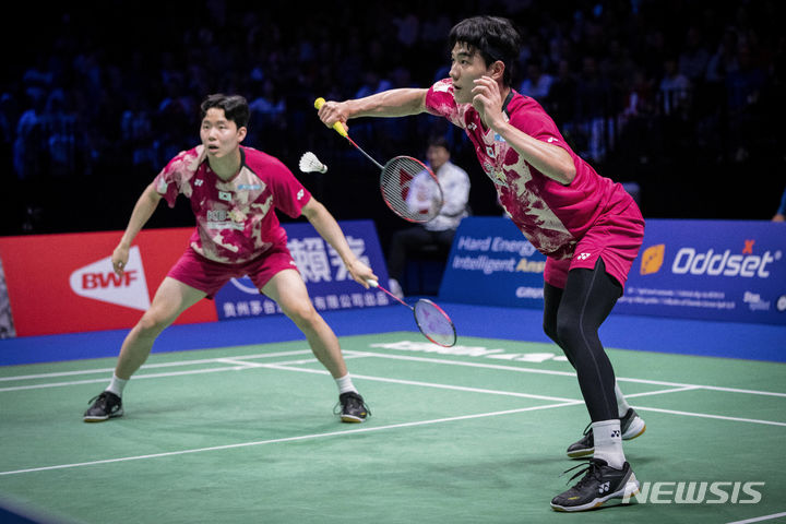 [코펜하겐=AP/뉴시스] 강민혁과 서승재가 27일(현지시각) 덴마크 코펜하겐의 로열 아레나에서 열린 2023 세계배드민턴연맹(BWF) 세계배드민턴선수권대회 남자 복식 결승전에서 킴 아스트룹-안데르스 스카룹 라스무센 조(덴마크)와 경기하고 있다. 강민혁-서승재는 덴마크를 2-1(14-21 21-15 21-17)로 꺾고 정상에 올랐다. 2023.08.28.