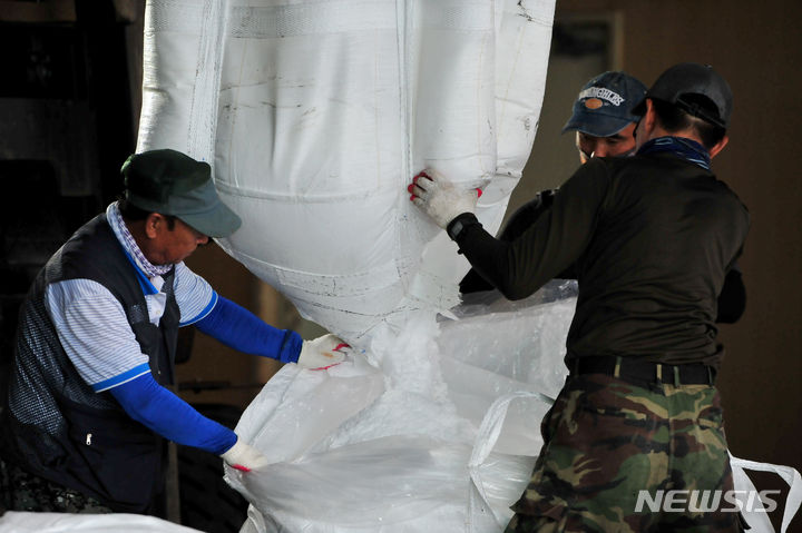 [영암=뉴시스] 이영주 기자 = 해양수산부가 천일염 유통 점검에 나선 30일 오전 전남 영암군 한 소금 유통 업체에서 직원들이 수입산 정제염을 다른 포대로 옮겨담고 있다. 2023.08.30. leeyj2578@newsis.com
