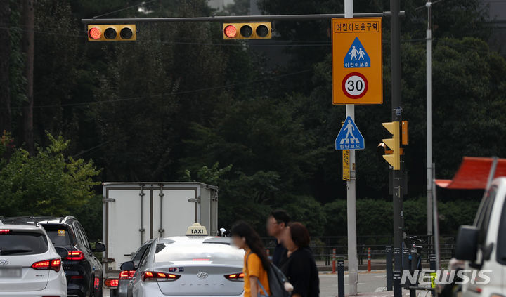 [서울=뉴시스] 김선웅 기자 = 경찰이 9월 1일부터 어린이보호구역(스쿨존) 심야 시간대 속도제한을 현행 시속 30km에서 40~50km까지 완화하겠다고 발표했다가 이를 하루만에 번복했다. 경찰청은 다음달 1일부터 어린이보호구역 시간제 속도제한 제도가 전국 총 8곳의 스쿨존에서 적용된다고 재발표했으나 이곳들은 이미 지난해부터 시간제 속도제한이 시범 운영되던 곳들로 사실상 바뀐 부분은 없는 셈이다. 31일 서울의 한 초등학교 앞 어린이보호구역의 모습. 2023.08.31. mangusta@newsis.com