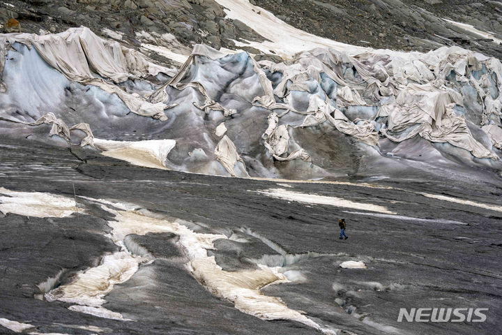 [곰스(발레주)=AP/뉴시스] 유럽연합(EU) 기후변화 감시 기구인 코페르니쿠스기후변화관리국(C3S) 사만다 버제스 부국장이 20일(현지시간) 소셜미디어(SNS) 플랫폼 X(옛 트위터)에 “유럽중기예보센터(ECMWF)의 11월 17일 잠정 지구 기온은 1991~2020년보다 1.17도 높았으며, 지구 기온이 처음으로 산업화 이전 수준보다 2도 이상 높았다”고 밝혔다. 사진은 스위스 연방기술연구소 빙하학자 마티아스 후스가 지난 6월16일 스위스 발레주 곰스 인근 론 빙하를 지나고 있는 모습으로 기사 본문과 직접적 관련은 없음. 2023.11.21. 