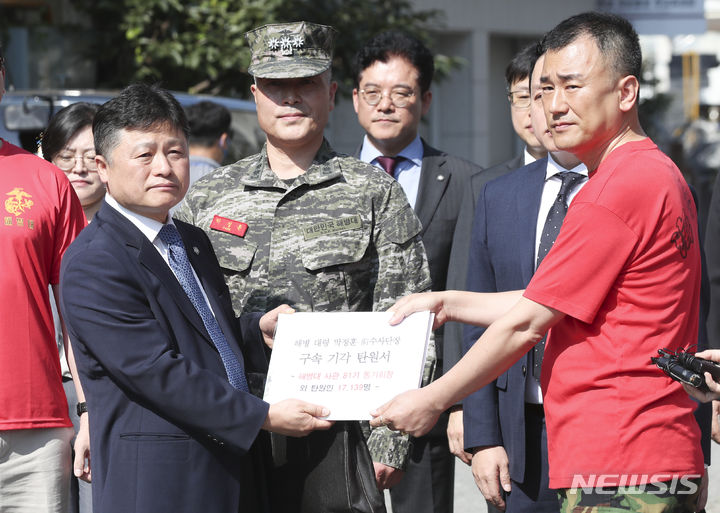 [서울=뉴시스] 김근수 기자 = 박정훈 전 해병대 수사단장 동기회장이 박 전 해병대 수사단장 변호인에게 1일 오전 서울 용산구 국방부 군사법원에 구속 전 피의자 심문(영장실질심사)에 출석에 앞서 탄원서를 전달하고 있다. 국방부 군 검찰은 박정훈 전 해병대 수사단장을 채 모 상병 순직 사건을 수사 항명 혐의와 상관 명예훼손 혐의를 더해 사전구속영장을 신청했다. 2023.09.01. ks@newsis.com