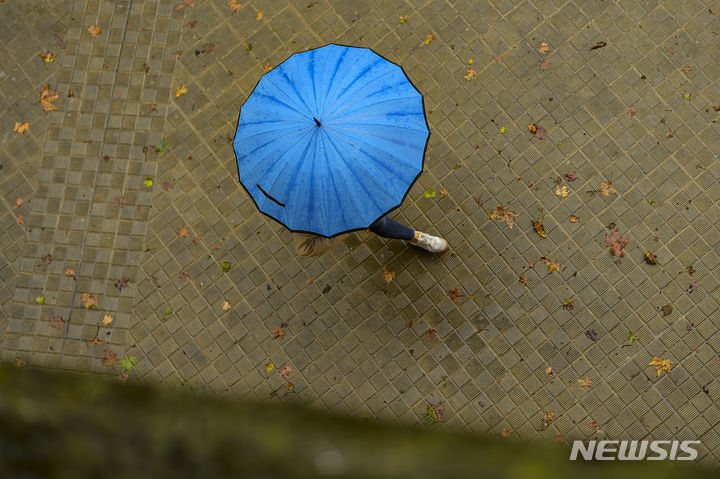 [팜플로나=AP/뉴시스]목요일인 22일은 수도권을 포함한 전국에 곳곳에 비가 내리겠다. 수도권 강수는 오전 중 그치겠다. 사진은 2023년 9월 2일(현지시간) 스페인 북부 팜플로나에 비가 내리자 한 여성이 우산을 쓰고 이동하는 모습. 2025.05.21.