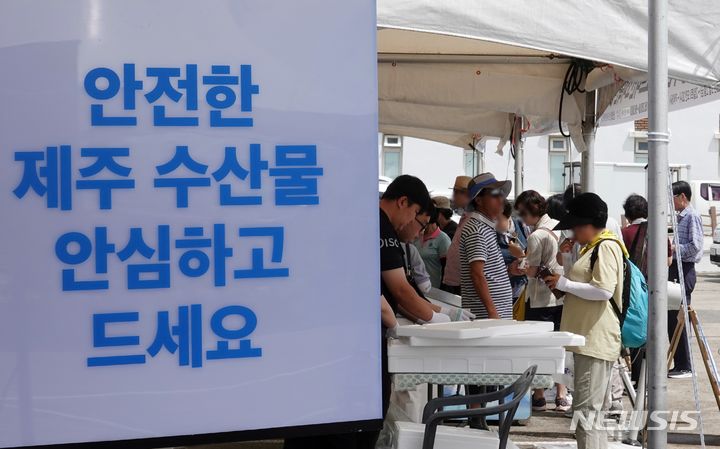 [제주=뉴시스] 오영재 기자 = 2일 오전 제주 서귀포시 성산포수협수산물직판장에서 열린 수산물 소비 촉진 행사 '성산해 성산해'에서 방문객이 제주산 갈치를 구매하고 있다. 2023.09.02. oyj4343@newsis.com 