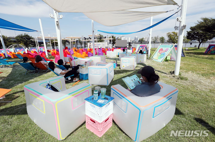 [서울=뉴시스] 김진아 기자 = 지난 2일 오후 서울 여의도 한강공원에서 열린 '책읽는 한강공원'을 찾은 시민들이 책을 읽고 있다. 서울시는 뚝섬·여의도 한강공원의 '책읽는 한강공원'을 새 단장하고 2일부터&nbsp; 10월28일까지 매주 토요일 낮 12시부터 저녁 8시까지 운영한다. 여의도는 '철수네 슈퍼', 뚝섬은 '영희네 문방구'라는 간판을 내건 야외 도서관에서 책을 빌려서 읽을 수 있다. 2023.09.02. bluesoda@newsis.com