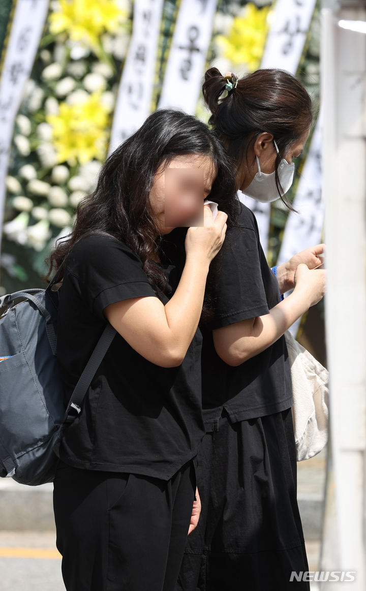 [서울=뉴시스] 고승민 기자 = 지난달 31일 서울, 전북교육청 소속 초등교사 A, B씨 2명이 극단 선택을 한 가운데 3일 A씨가 재직했던 서울 양천구의 한 초등학교에서 추모객이 눈물을 훔치고 있다. 2023.09.03. kkssmm99@newsis.com