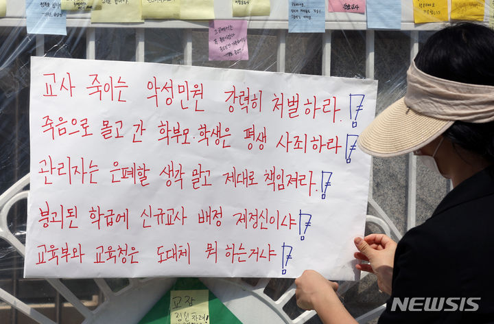 [서울=뉴시스] 고승민 기자 = 지난달 31일 서울, 전북교육청 소속 초등교사 A, B씨 2명이 극단 선택을 한 가운데 3일 A씨가 재직했던 서울 양천구의 한 초등학교에서 관계자가 각종 사안 해결을 촉구하는 대자보를 부착하고 있다. 2023.09.03. kkssmm99@newsis.com