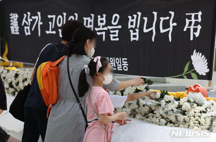[서울=뉴시스] 고승민 기자 = 지난달 31일 서울, 전북교육청 소속 초등교사 A, B씨 2명이 극단 선택을 한 가운데 3일 A씨가 재직했던 서울 양천구의 한 초등학교에서 추모객이 헌화를 하고 있다. 2023.09.03. kkssmm99@newsis.com