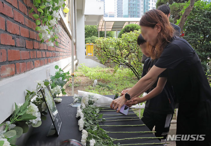 [서울=뉴시스] 김금보 기자 = 서이초 사망 교사 49재를 맞은 4일 오전 서울 서초구 서이초등학교에서보호자와 어린이가 헌화하고 있다. 2023.09.04. kgb@newsis.com