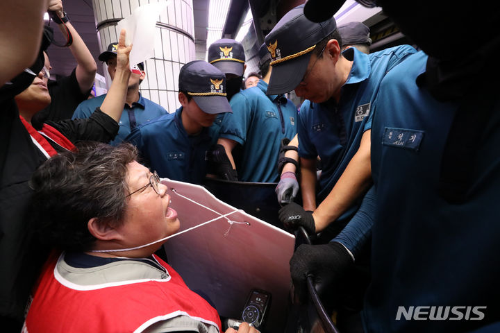 [서울=뉴시스] 황준선 기자 = 전국장애인차별철폐연대(전장연) 회원들이 5일 오전 서울 지하철 1호선 서울시청역에서 열린 2024년 장애인권리예산 쟁취 및 오세훈 서울시장 혐오정치 고발 '출근길 지하철 탑니다' 선포 기자회견에서 지하철 탑승을 위해 경찰과 대치하고 있다. 2023.09.05. hwang@newsis.com